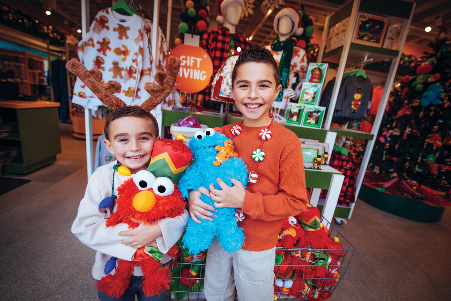 Children hold Christmas plush toys from Sesame Place.