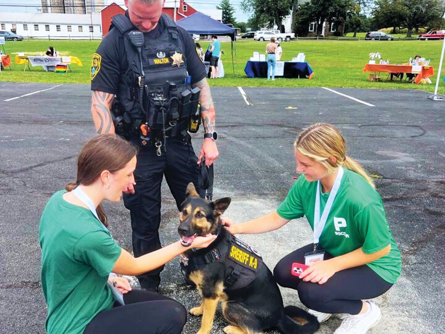 Pennridge Upstanders Erin Farr and Riley Williams visit with a Bucks County Sheriff’s Officer and his K9.