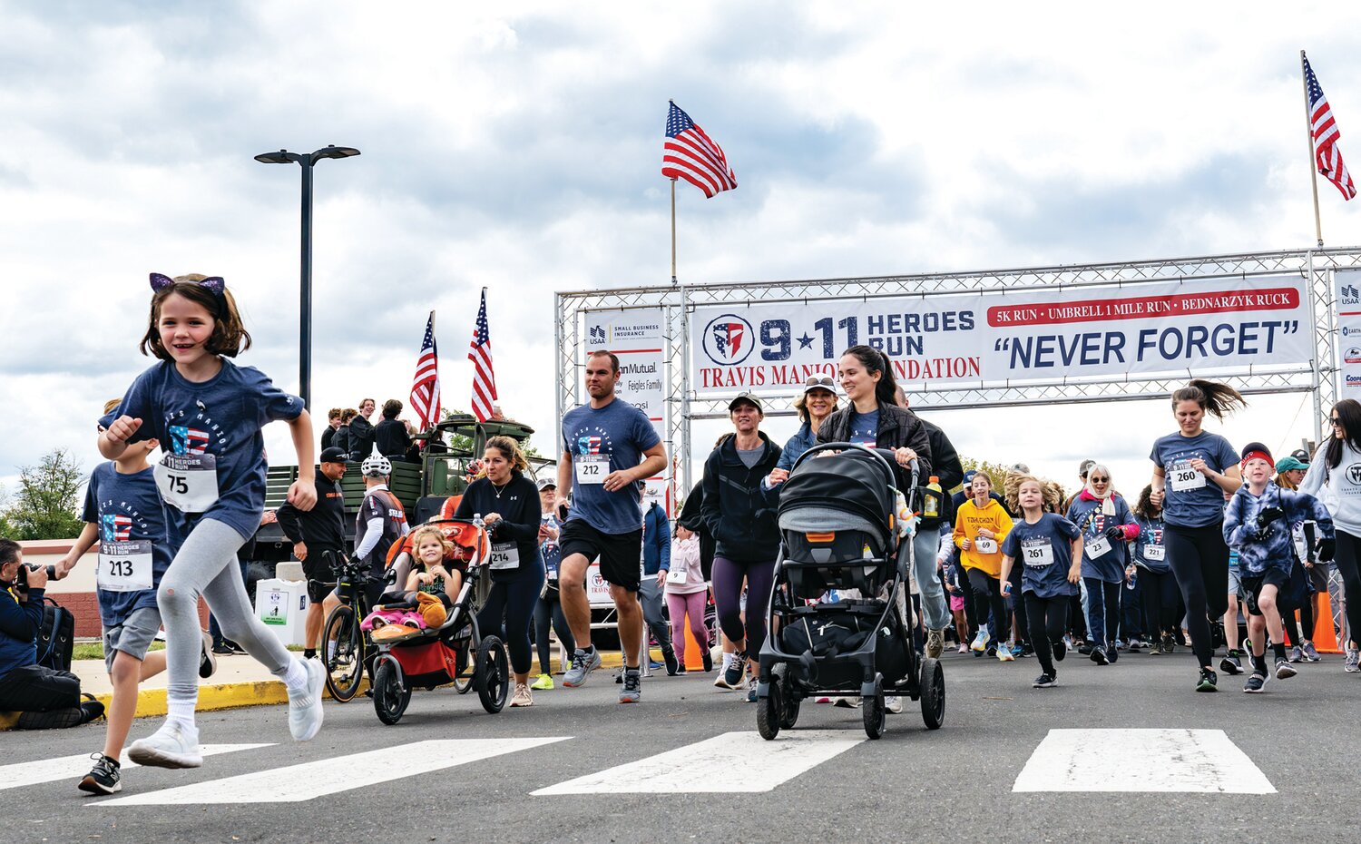 Runners, walkers and stroller-riders cross the starting line.