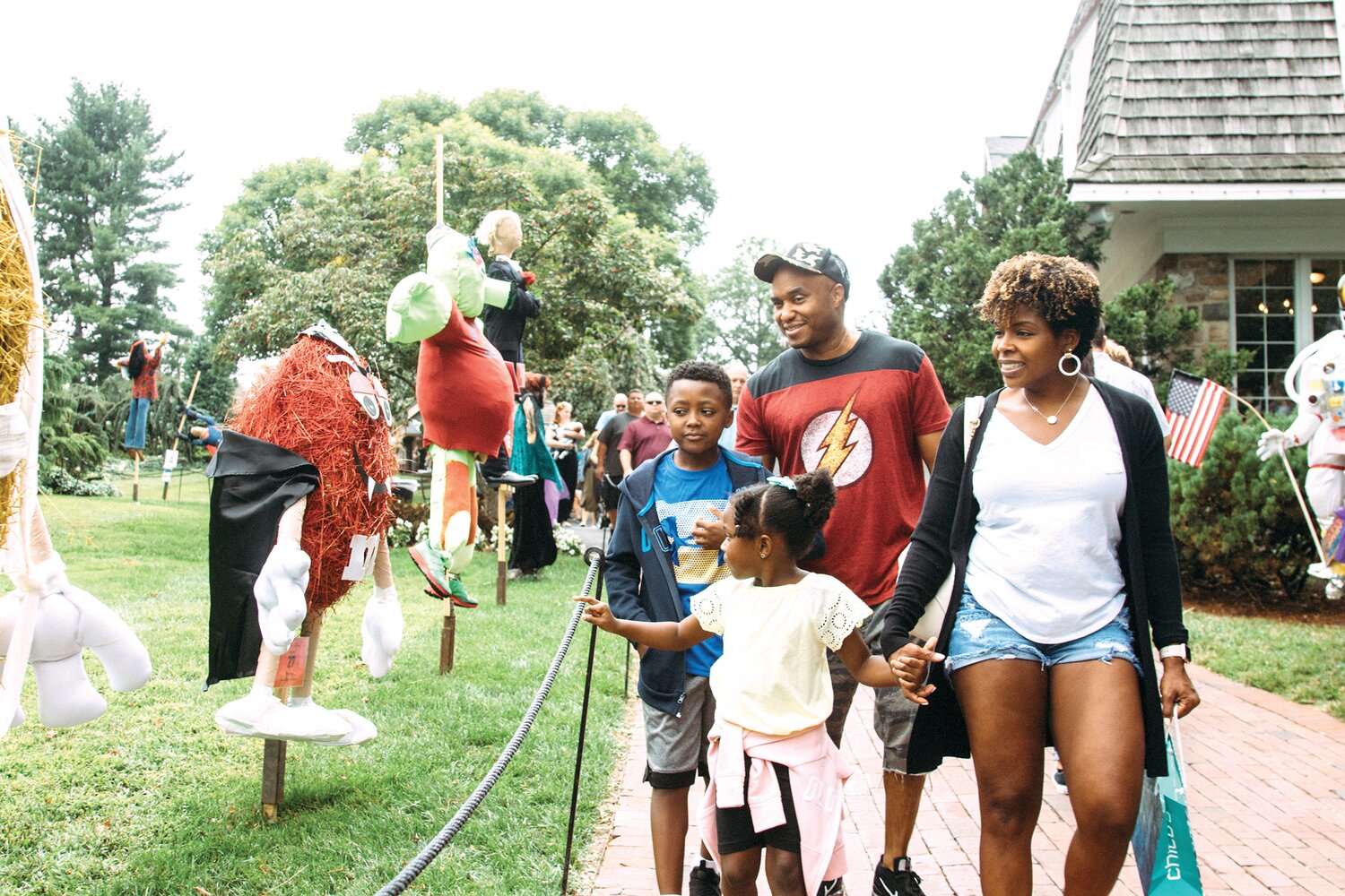A family takes in the scarecrows at Peddler’s Village during a fall festival.