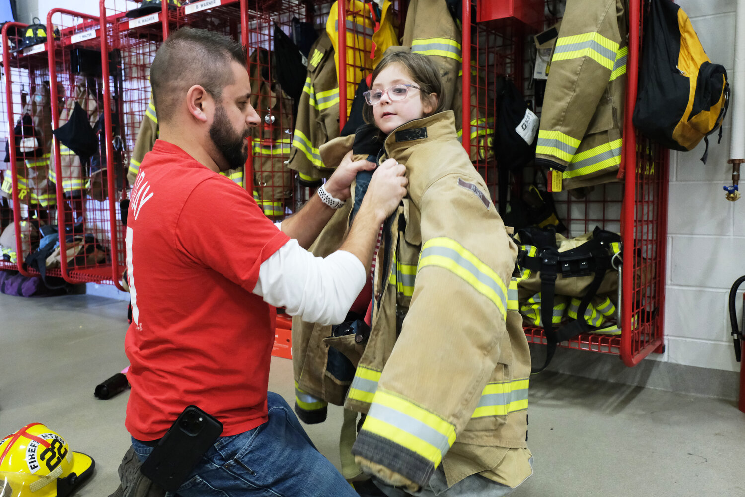 Tim Burns, of Middletown, dresses  his daughter Amelia, 4, in a full fire uniform.