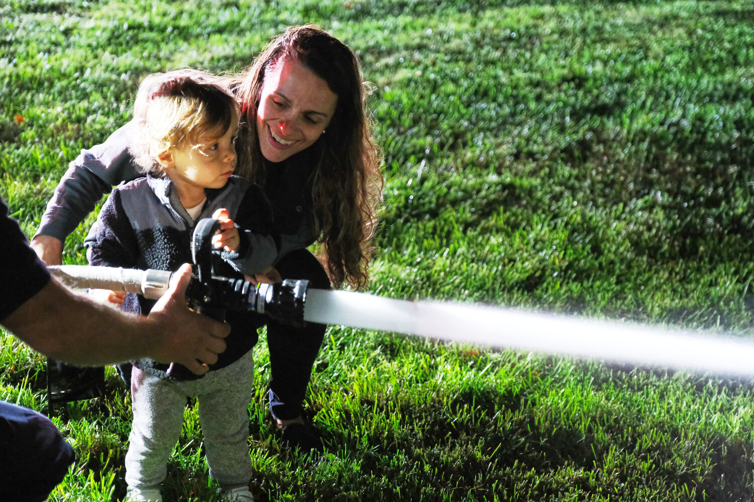 Maria Lacovara, of New Hope, helps her son Dominic work the fire hose.