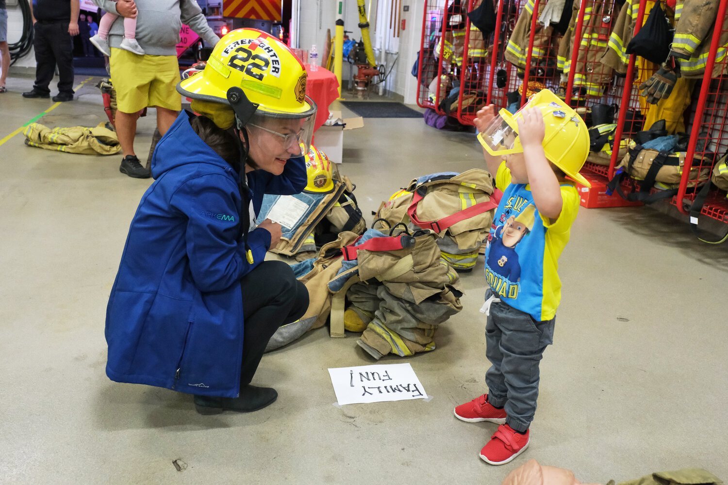 Jessica DeMott and Cameron MacInnis, 3, of Middletown, try on the equipment.
