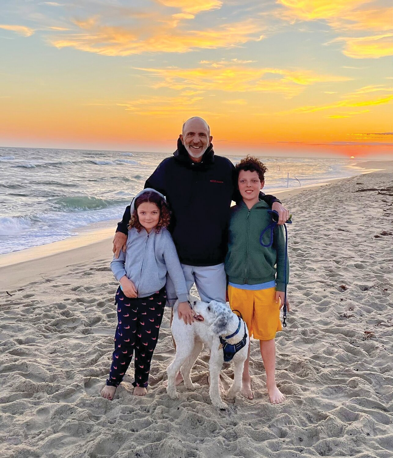 Bucks County Poet Laureate Tom Mallouk and two of his three grandchildren, along with his sheepadoodle, Nellie, enjoys the beach. Pictured are Sebastian and Aurora. Not pictured is a third grandchild, Lukas.