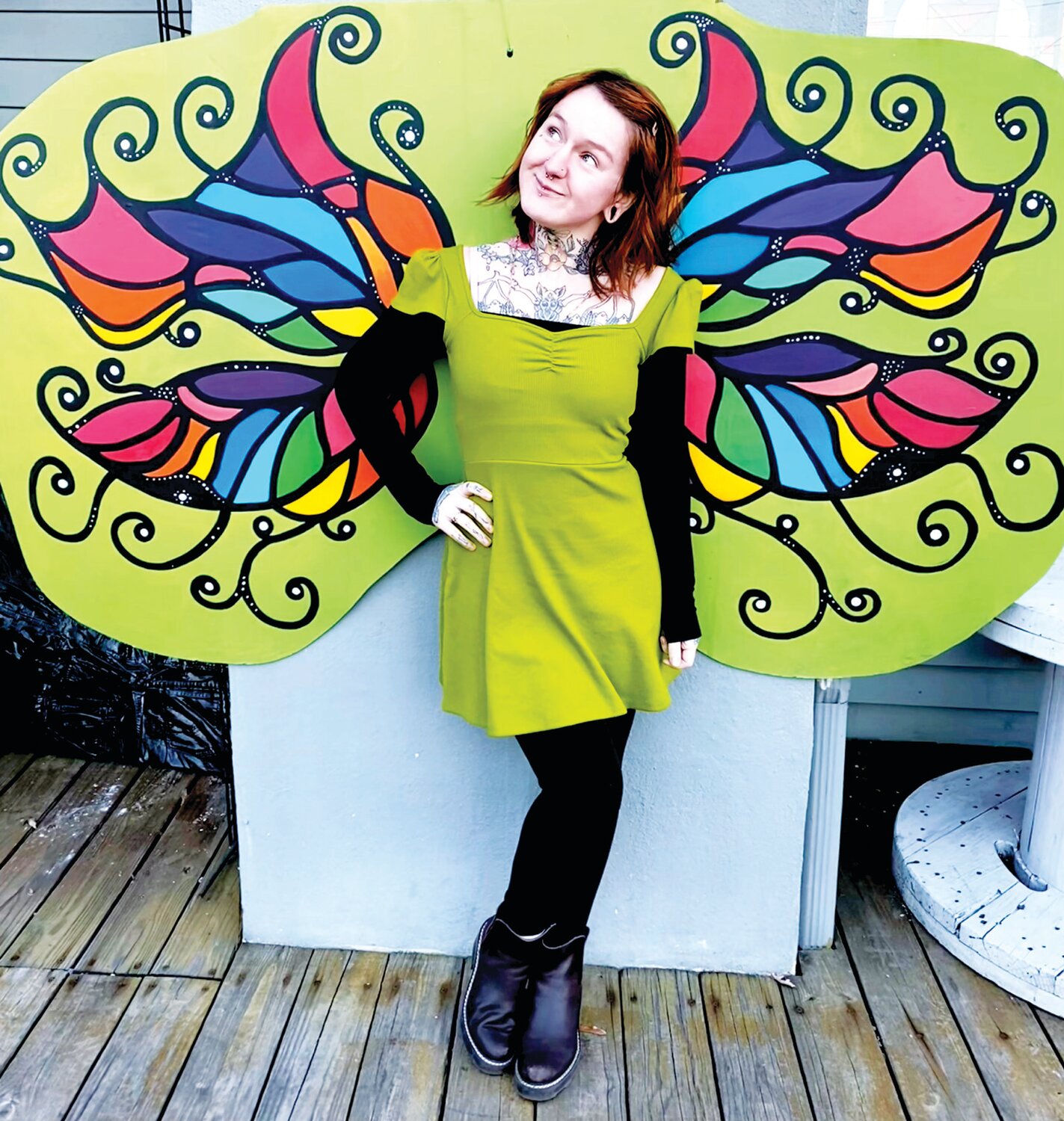 Hope Gaburo poses with Scrambled’s wings, which were created by Erin Simmons, who opened the gallery but turned it over to Gaburo before she died in February 2022.