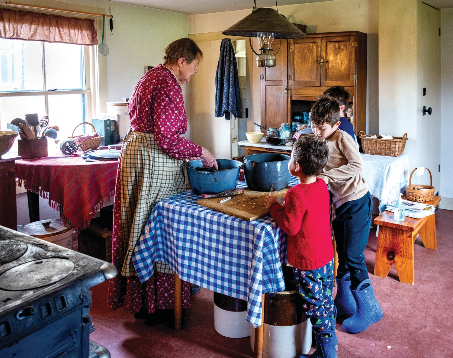 Farm worker Jane Kidder makes applesauce with the help of, from left, Rafa Bliss Woodbury, Luca Bliss Woodbury and Mars Bliss Woodbury.