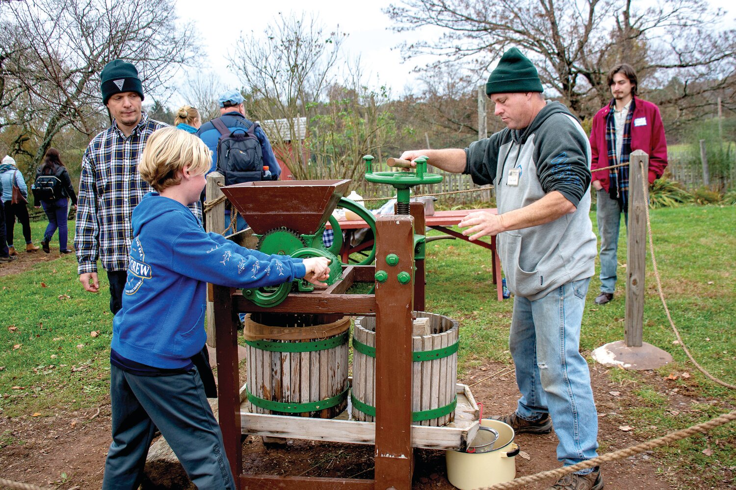 Visitors participate in the process of making apple cider at Howell Living History Farm.