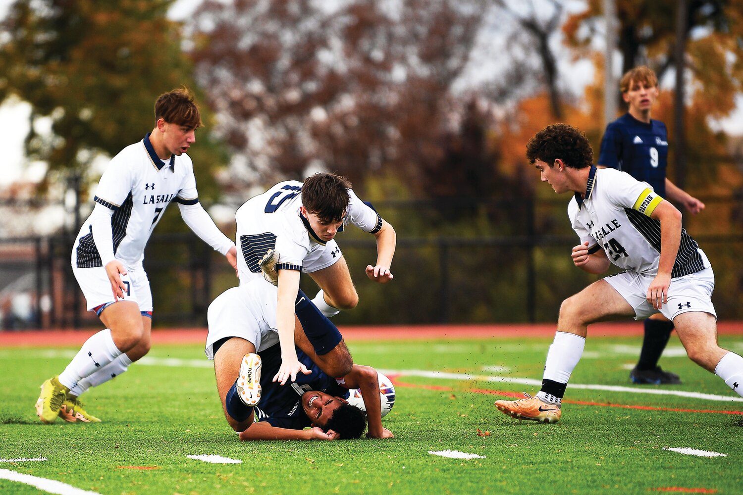 Council Rock North’s Ari Pollack gets knocked to the ground by La Salle’s Joey Kmetz, left, as La Salle’s Liam Connaghan falls over top of him while going for a pass.