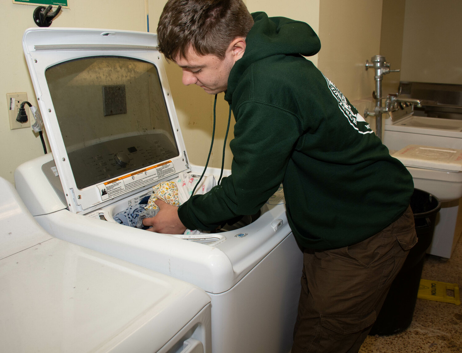 Volunteer Jacob Schroeder of the New Hope-Solebury Bridge Program does some laundry at The Baby Bureau’s site in Warminster.