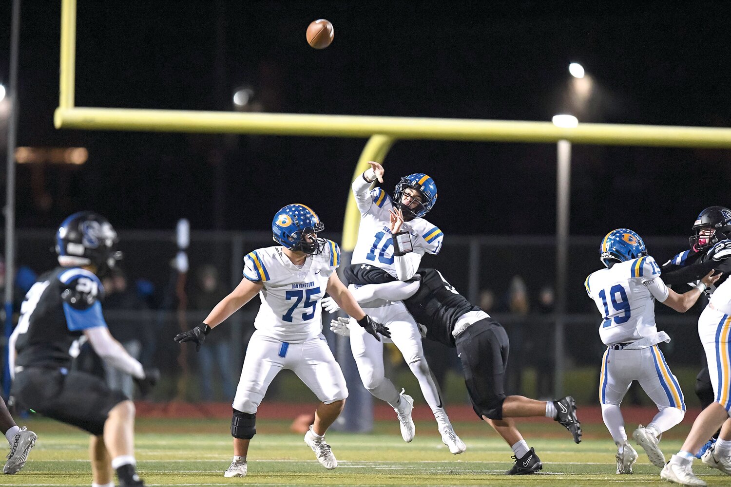 Downingtown West’s Quinn Henicle barely gets off a pass attempt while getting hit by Central Bucks South’s Rolan Hess.