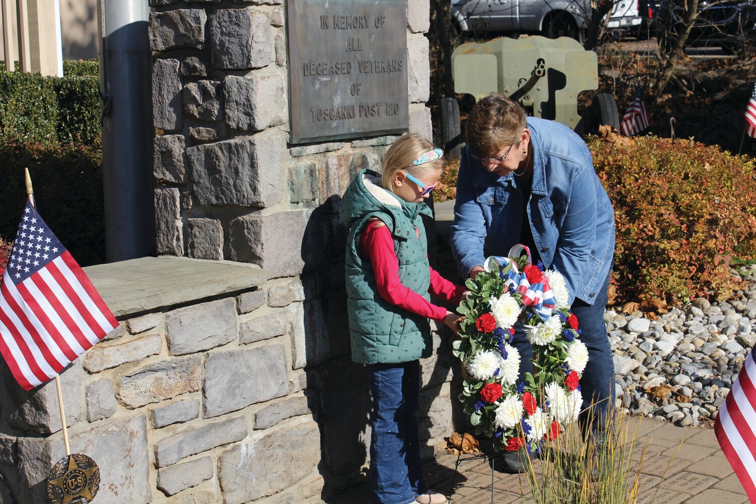 Kathy Miller, auxiliary president, and Annabelle Miller, junior auxiliary member, place a memorial wreath during the Veterans Day ceremony in Lambertville, N.J.