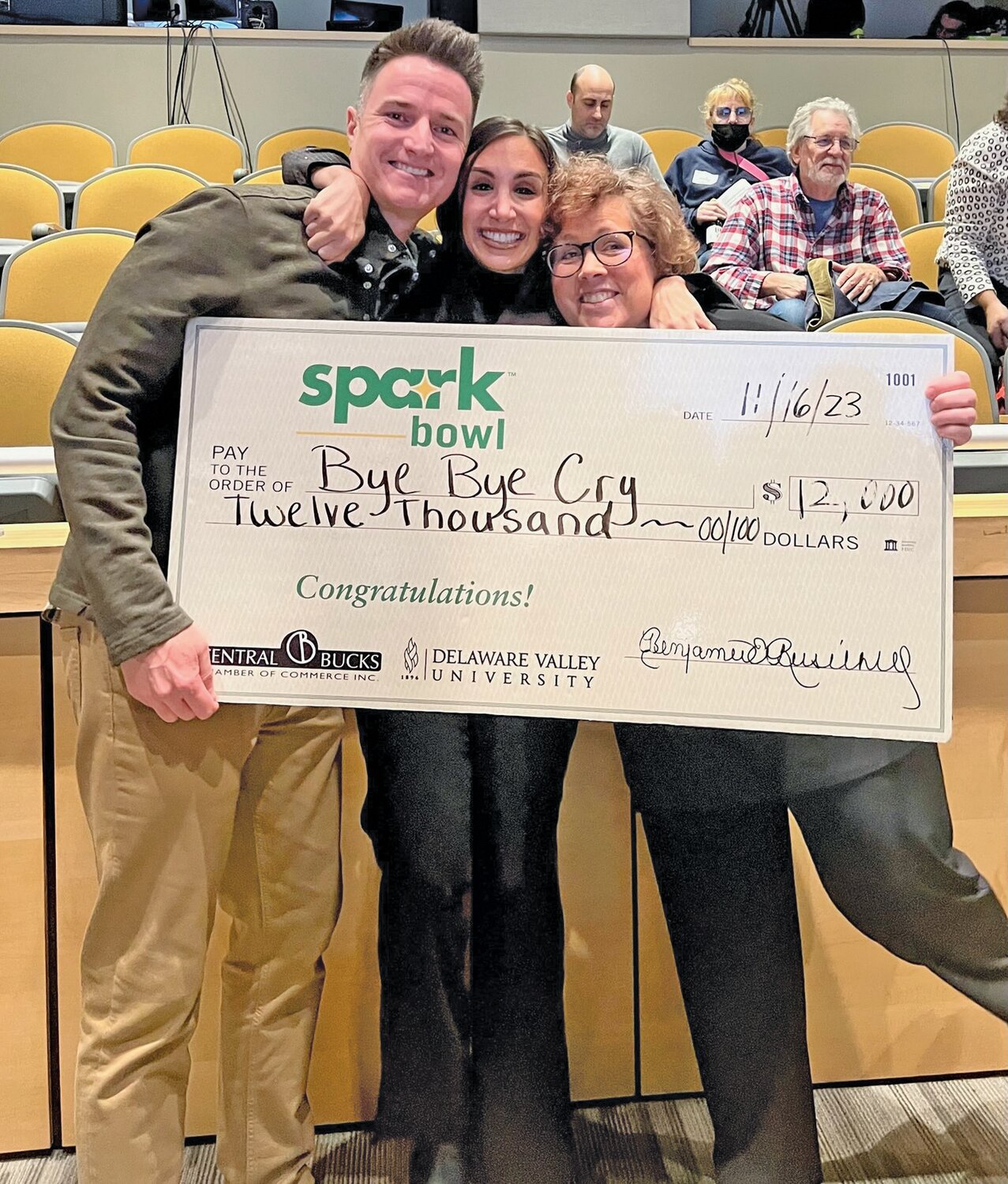 Samantha Myers, founder of ByeByeCry (center) accepts a $12,000 check from the recent Spark Bowl at Delaware Valley University, with husband Eddie and creative director Anita Haley.