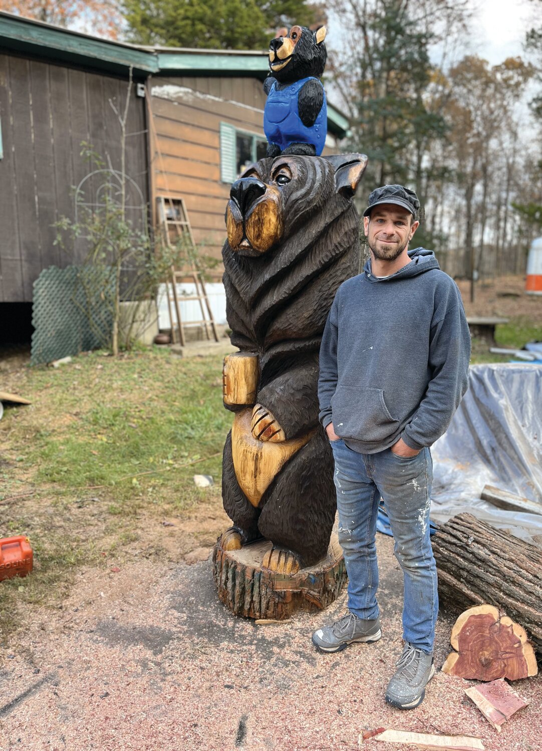 Neil Gross of Tinicum Township, who is proud of his native American ancestry, poses with his chainsaw bears.
