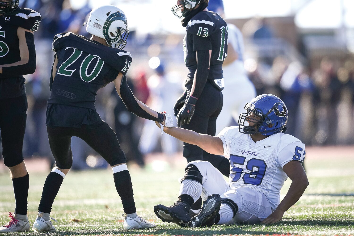 Quakertown’s Keondre Lopez gets a helping hand after a play in the second quarter from Pennridge’s Joe Hamburger.