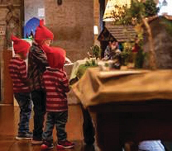 Three children pause to read about a Nativity scene in Glencairn’s Great Hall during the World Nativities exhibition.