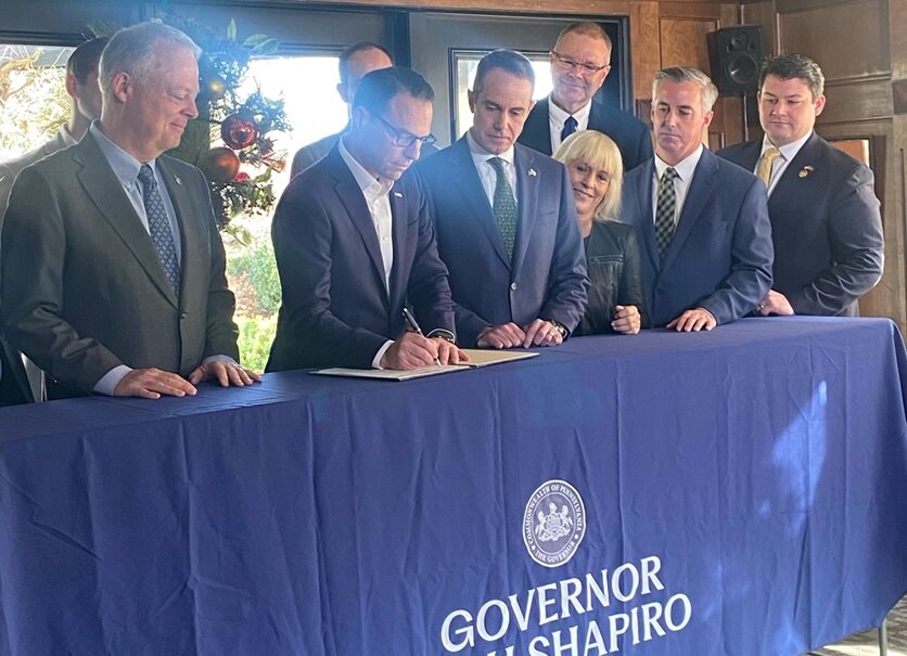 Flanked by Rep. Perry Warren, left, and PA Sen. Steve Santarsiero, right, Pennsylvania Governor Josh Shapiro signs House Bill 735 Monday at The Yardley Inn. It creates the Flood Insurance Premium Assistance Task Force.