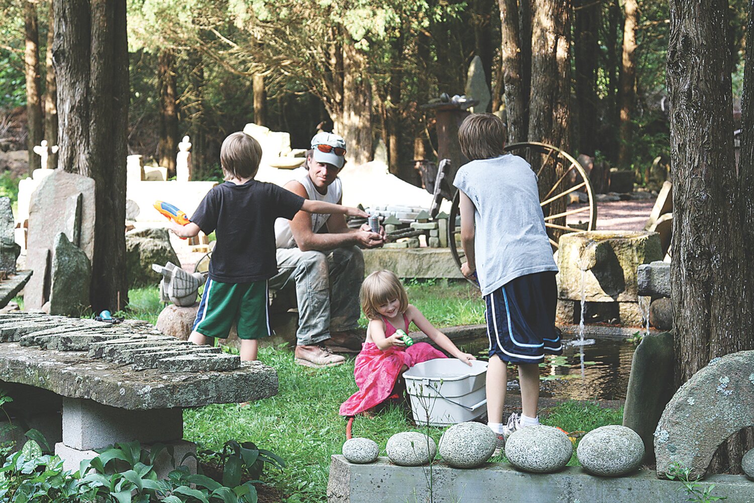 Steven Snyder with Justin’s children, Nathan, Hayden and Cadence Anchinsko, at Cedar Maze playing at the pond.