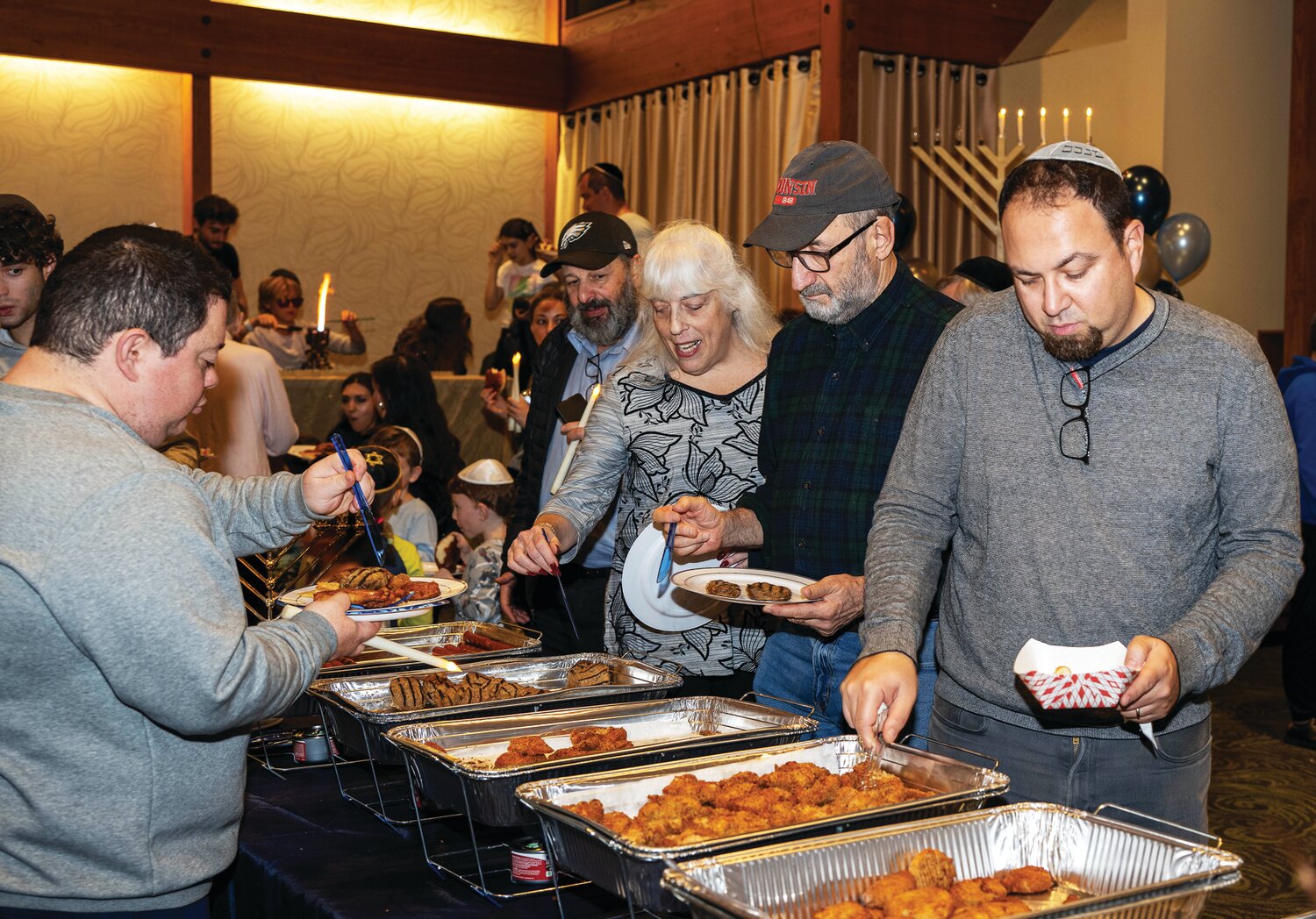 Attendees line up for dinner at the Family Chanukah Celebration in Newtown Dec. 10.
