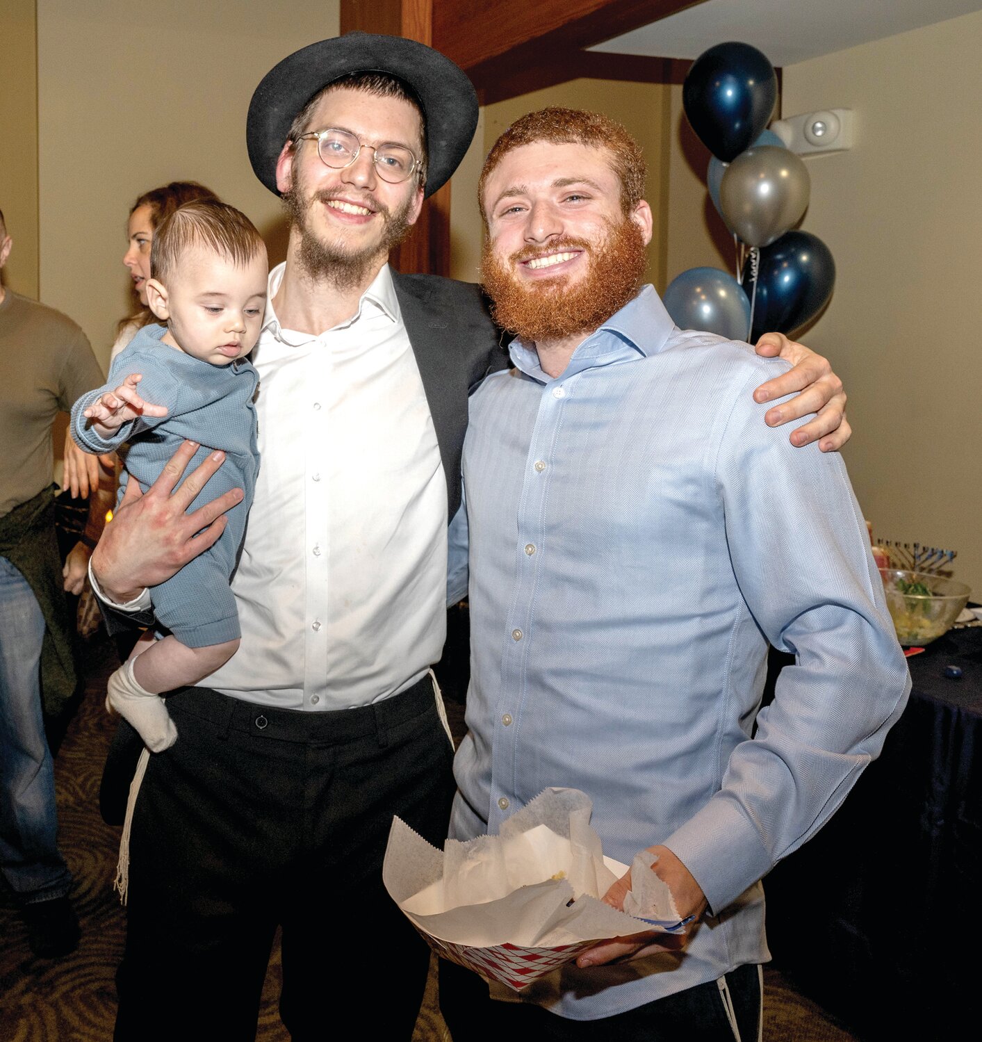 Uziel Weinstein, left, holding baby Mendele Weinstein, and Shneur Piekarski, right.