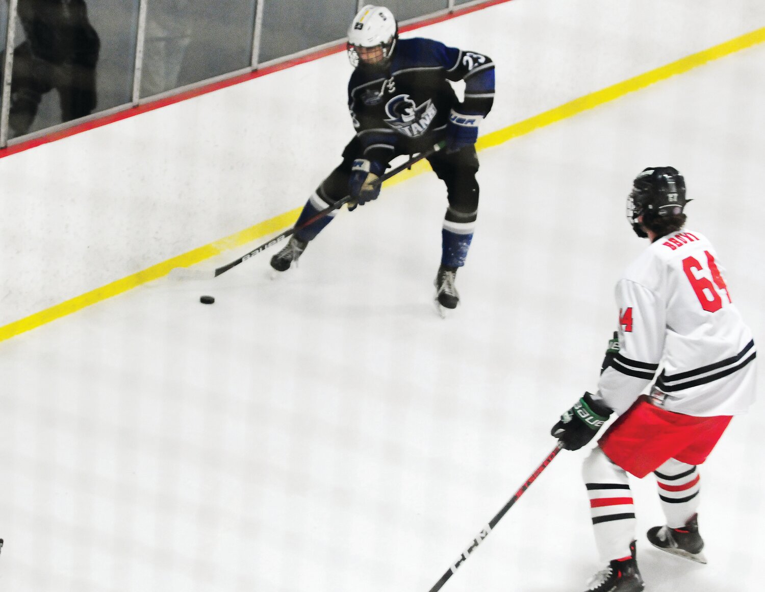Colin Mendam handles the puck for CB South defended by David Brown for CB East.