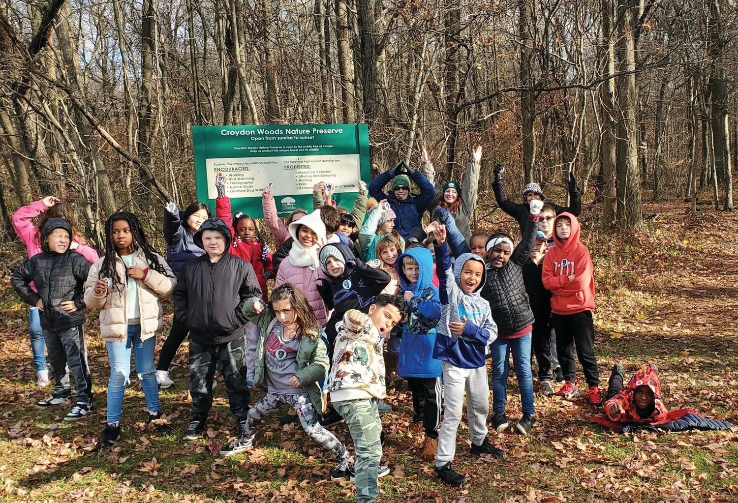 Fourth and second graders enrolled in the Guardian Tree Program at Keystone Elementary School strike their guardian poses after protecting native seedlings in Croydon Woods Nature Preserve.