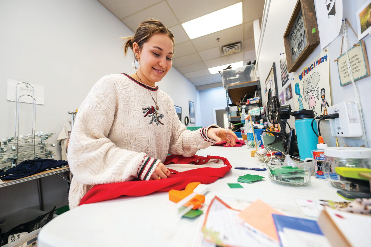 Hannah McKenney tags clothes with prices so they can be displayed and sold at Worthwhile Thrift, a nonprofit working to end modern day slavery.