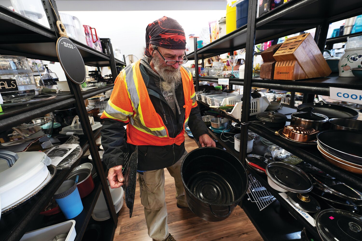 One of Worthwhile Wear’s regular customers considers a large cooking pot he found in the cookware area of the Plumstead thrift store.