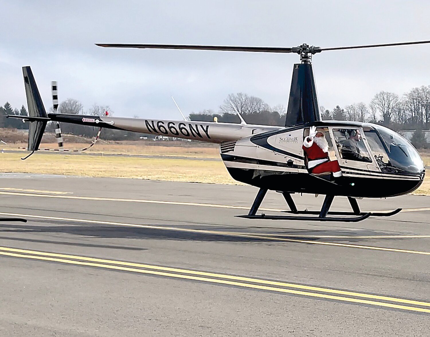 A helicopter carrying Santa Claus touches down at Doylestown Airport on Dec. 9 to distribute gifts. Leading Edge Aviation of Buckingham has hosted Santa’s arrival for more than 20 years.