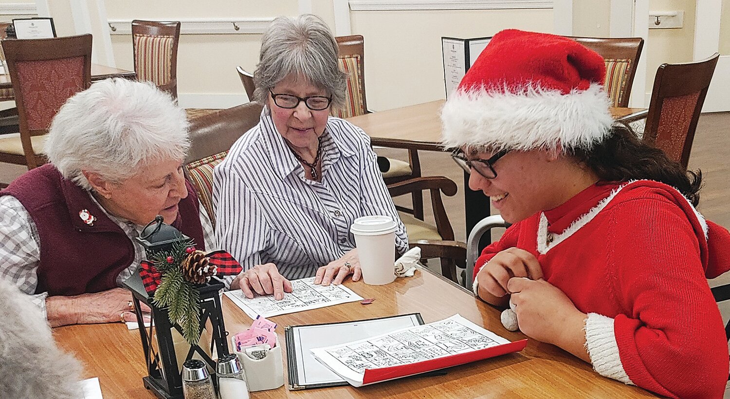 Residents of Morningside House of Towamencin in Montgomery County put their heads together to match pictures with the Christmas carols they depict as Zoe from Horsin’ Around, a Bucks County 4-H club, lends a hand. Members of the 4-H club visited the center to spread some holiday cheer.