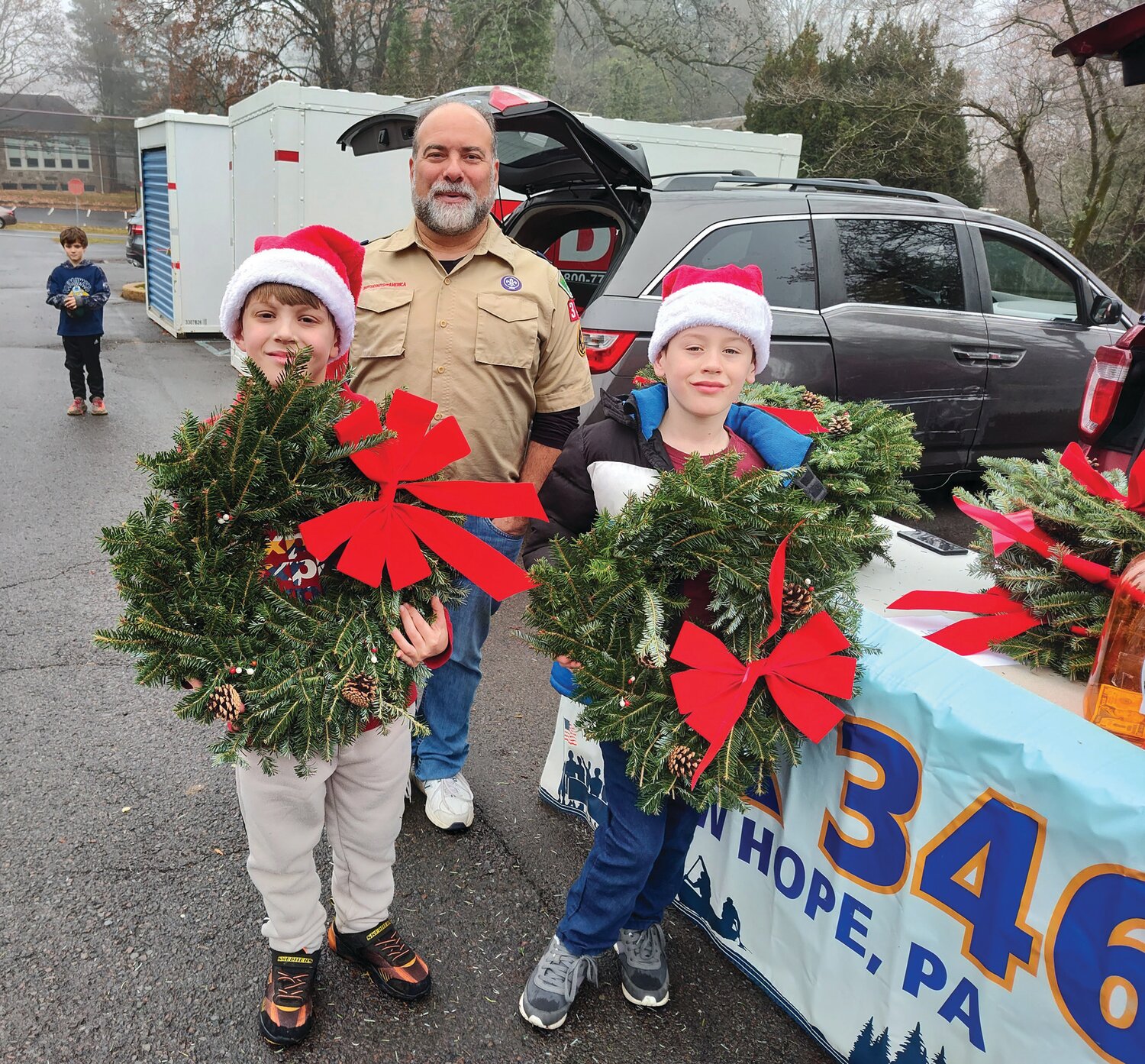 It’s the fundraising time of the year. Groups are asking for donations or raising funds in many ways. Two members of the Wolf Pack, Cub Scouts Pack 3464, sold Christmas wreaths for the Scouts outside Trinity Episcopal Church in Solebury during the church’s St. Nicholas Fair Dec. 2. Oscar Hammerstein IV, left, is with his friend John Jorgensen. Vince Napoli, Webelos Arrow of Light den leader, is behind the boys.