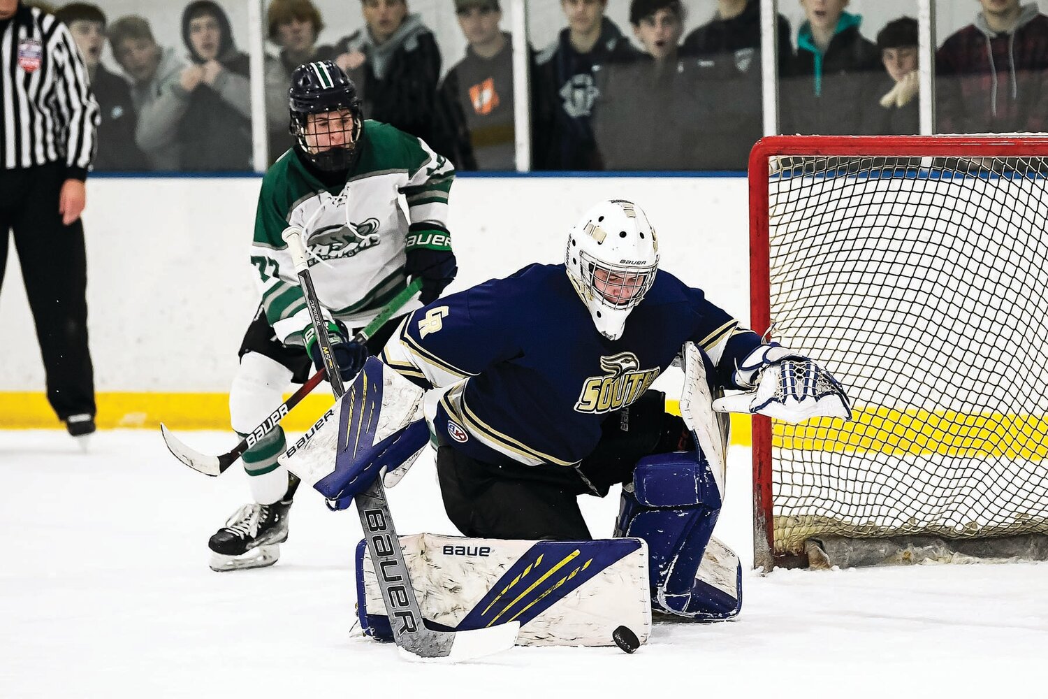 Council Rock South goalie Trevor Rakszawski  scrambles to gather a loose puck in front of the net as Pennridge’s Andrew Savona closes in.
