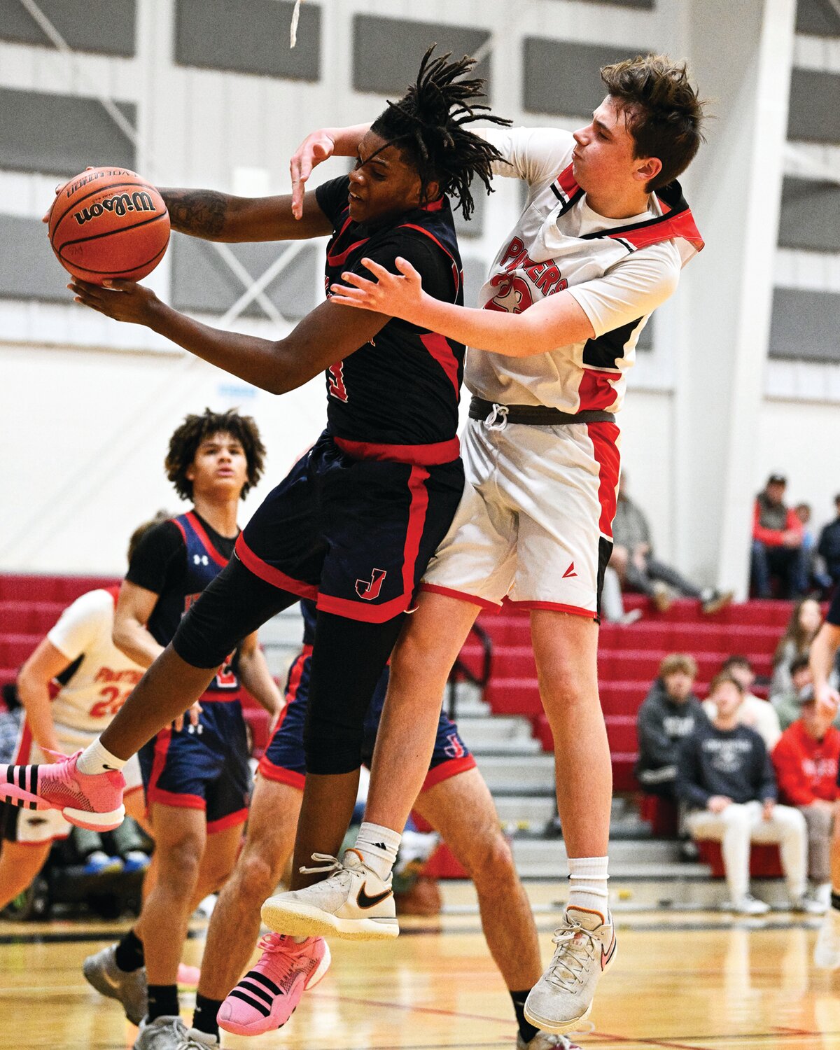 Jenkintown’s Desmond Trail gets the rebound in front of Plumstead Christian’s Drew Mandia.