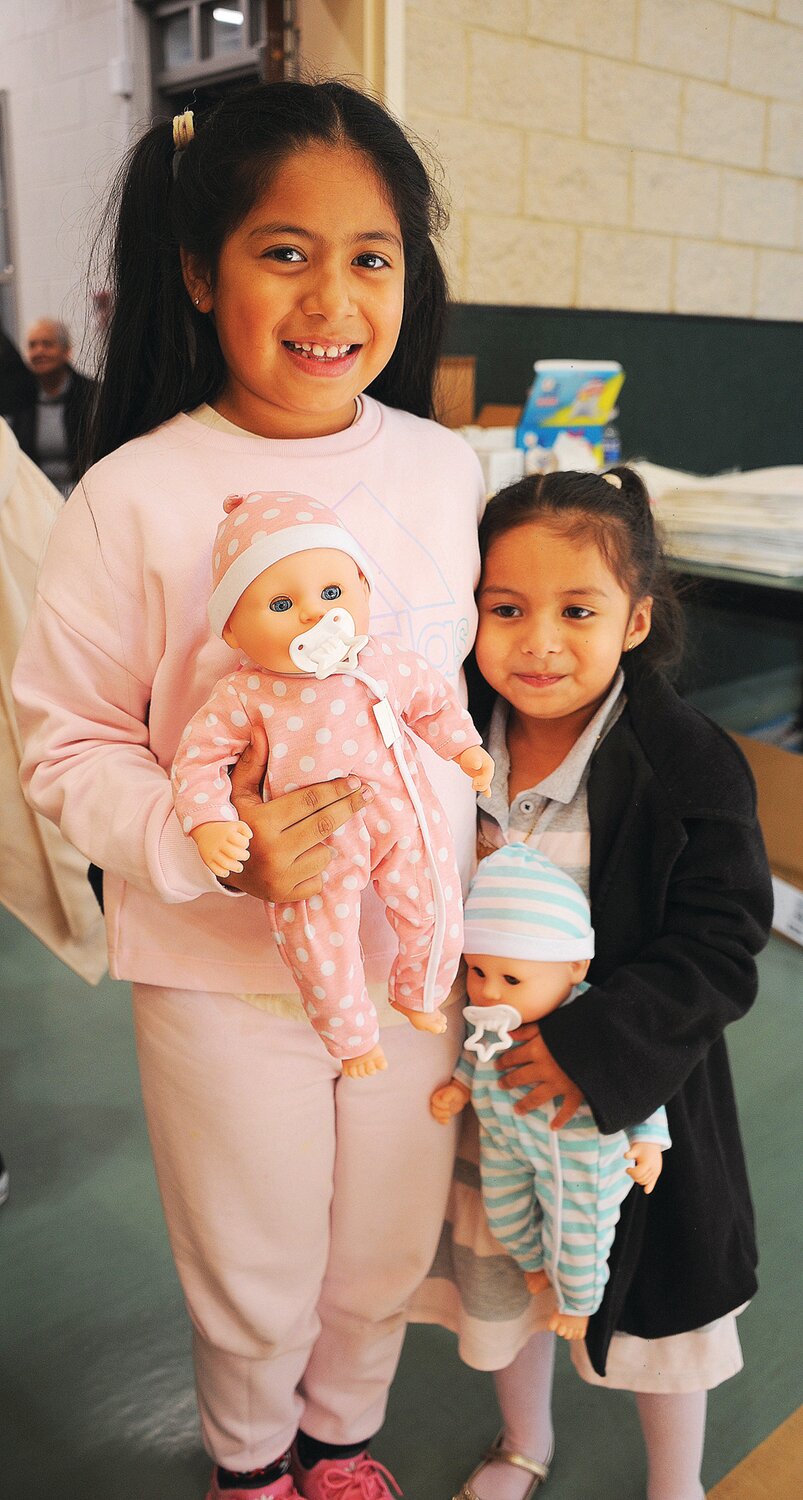 Ashley and Chaley hold twin baby dolls.