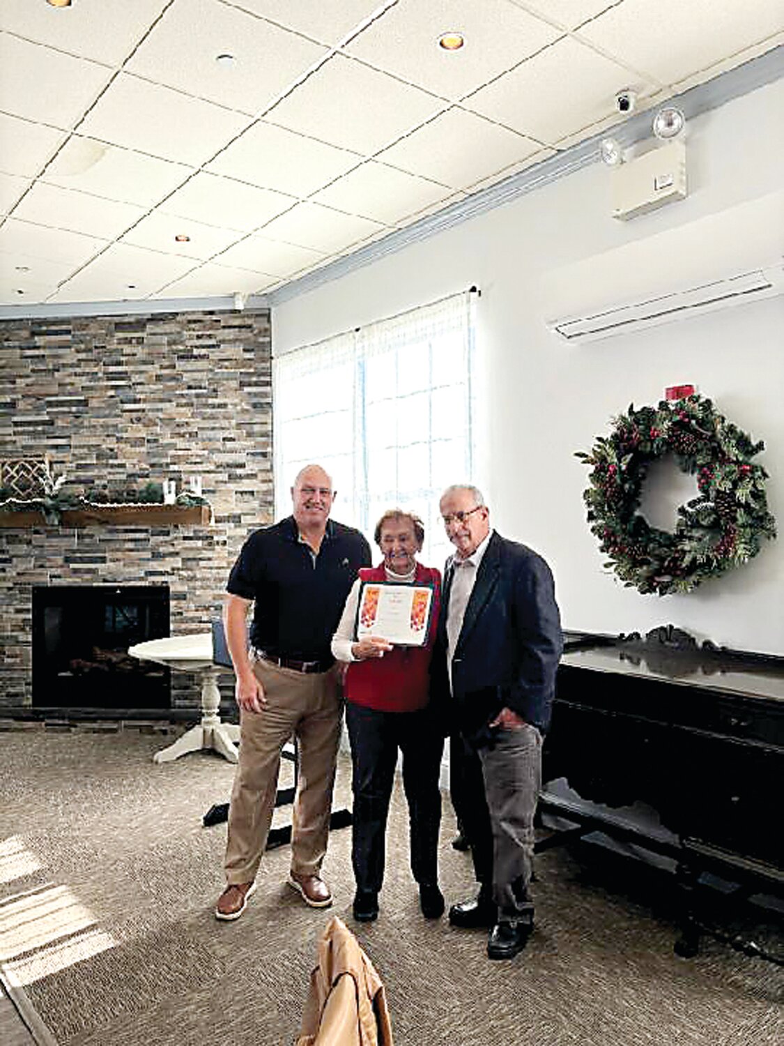 Jason Cartwright, left, representing Warminster Rotary Club, presents Evie Dugan, the longest running volunteer at Warminster Food Bank, with a Certificate of Merit in honor of her 45 years of service to Warminster Food Bank. With them is Mike Cerino, executive director, Warminster Food Bank.