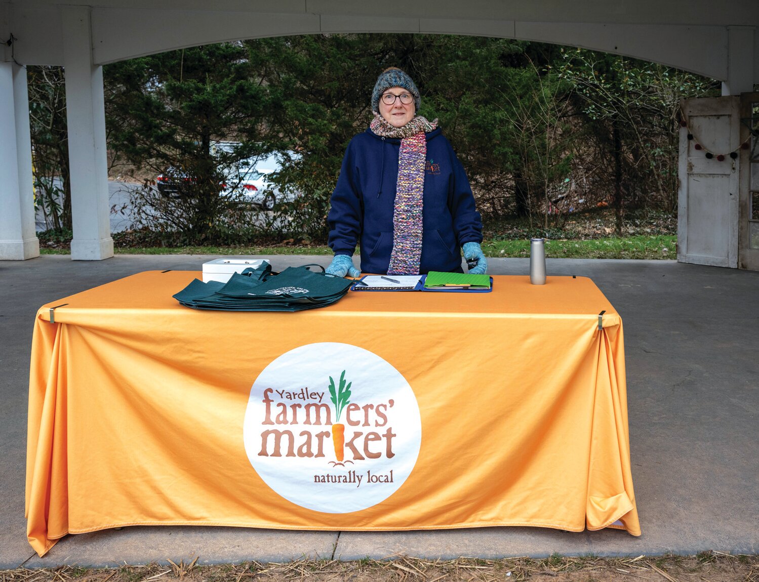 Laura Thomforde, farmers market volunteer, works the registration and information table.