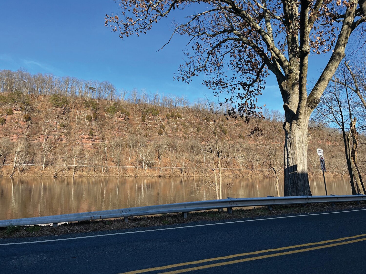 Trees on the New Jersey side are reflected in the Delaware River. Geotab has named River Road one of America’s Quietest Routes, also called America’s Best, Loneliest Roads.