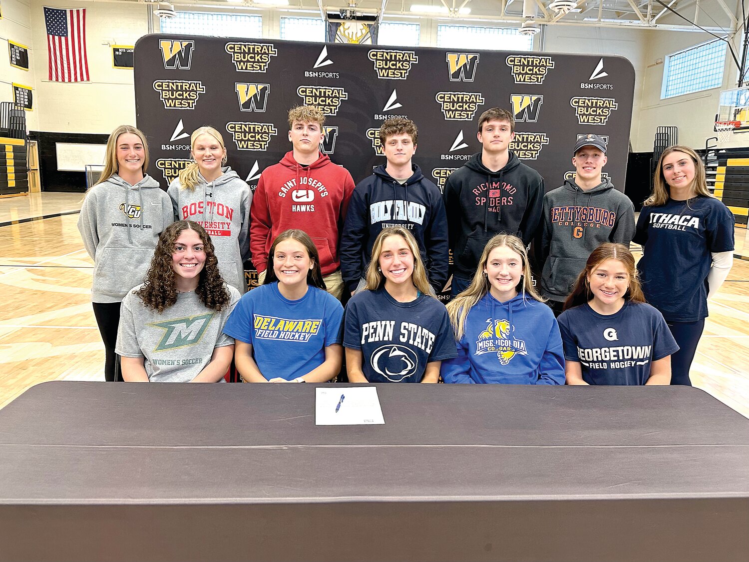At CB West’s college commitment recognition ceremony are seniors, from left, front row, Alexis Castro, Lily Cosner, Mimi Duffy, Sienna Lawson, Nina Mayro; back row, Kate Weyer, Chloe Dryden, Sam Greer, Jimmy Donnelly, Matt Jacobsen, Connor Mangan and Molly Gibson.