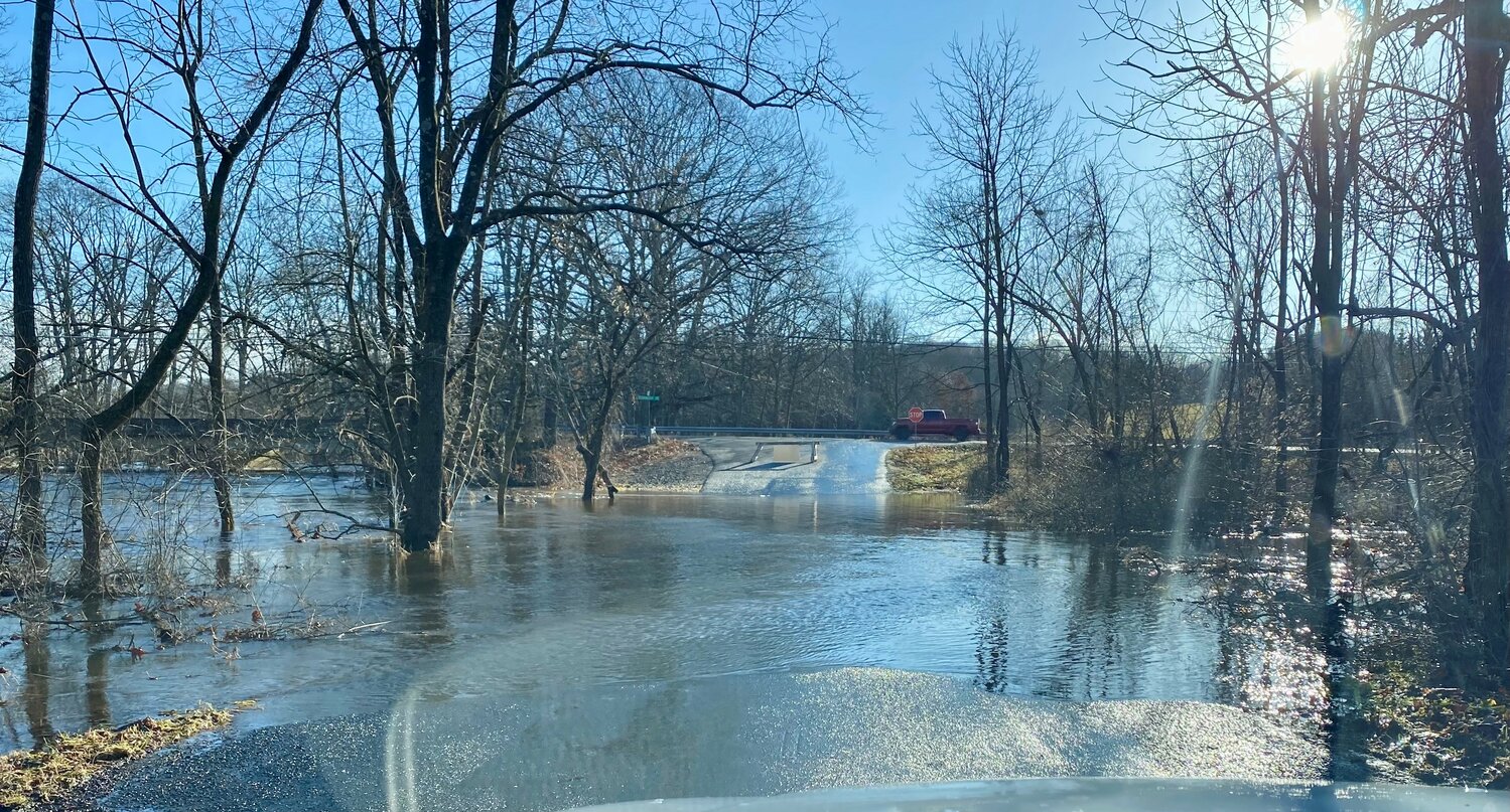 Tohickon Creek flooding Wednesday renders Deer Run Road impassable in Bedminster Township. It was just one of many roads blocked by flood waters, fallen trees and downed wires in the wake of Tuesday night’s storm.