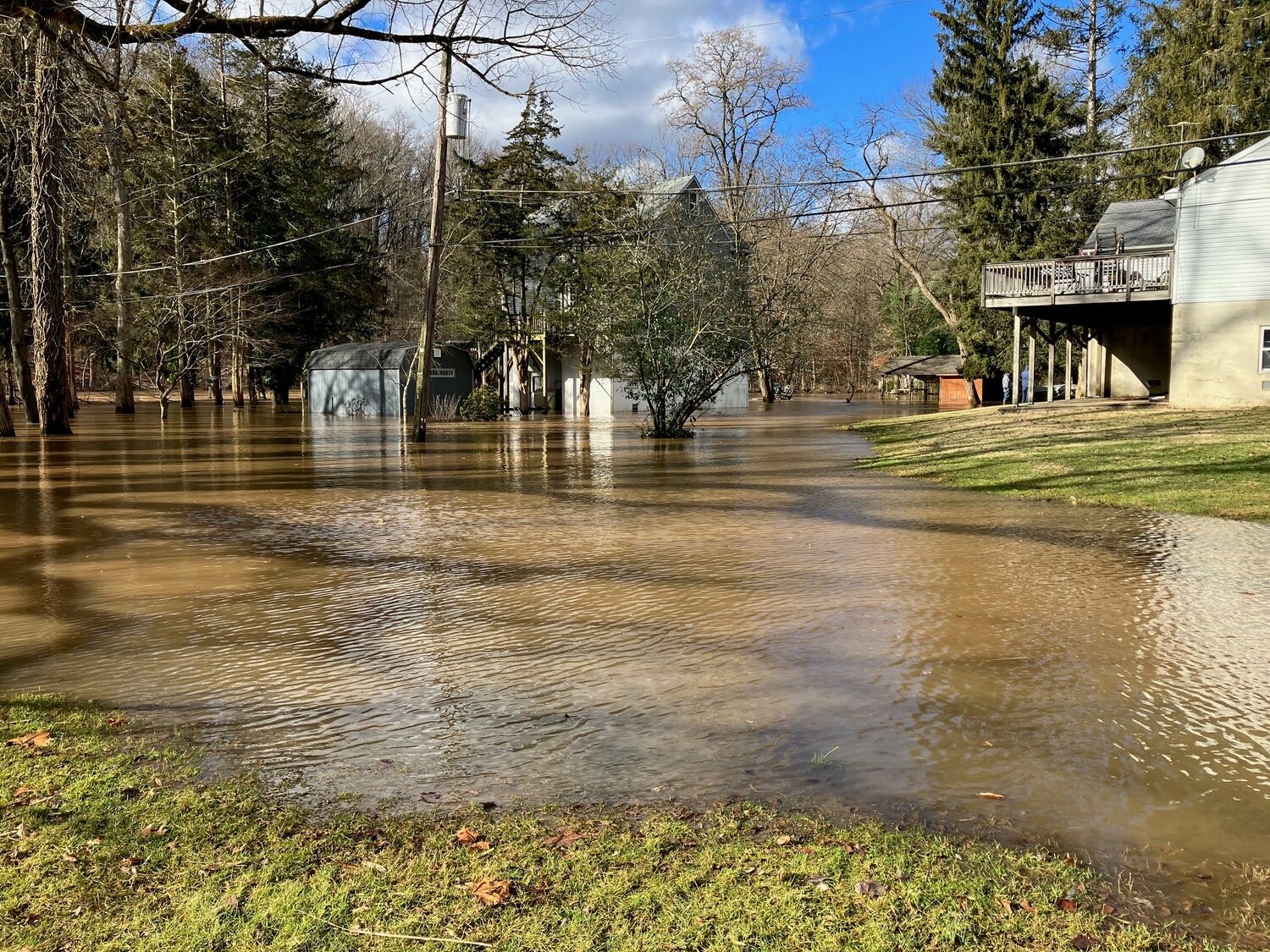 Two men survey the flooding on Mistletoe Drive Wednesday near the Neshaminy Creek.
