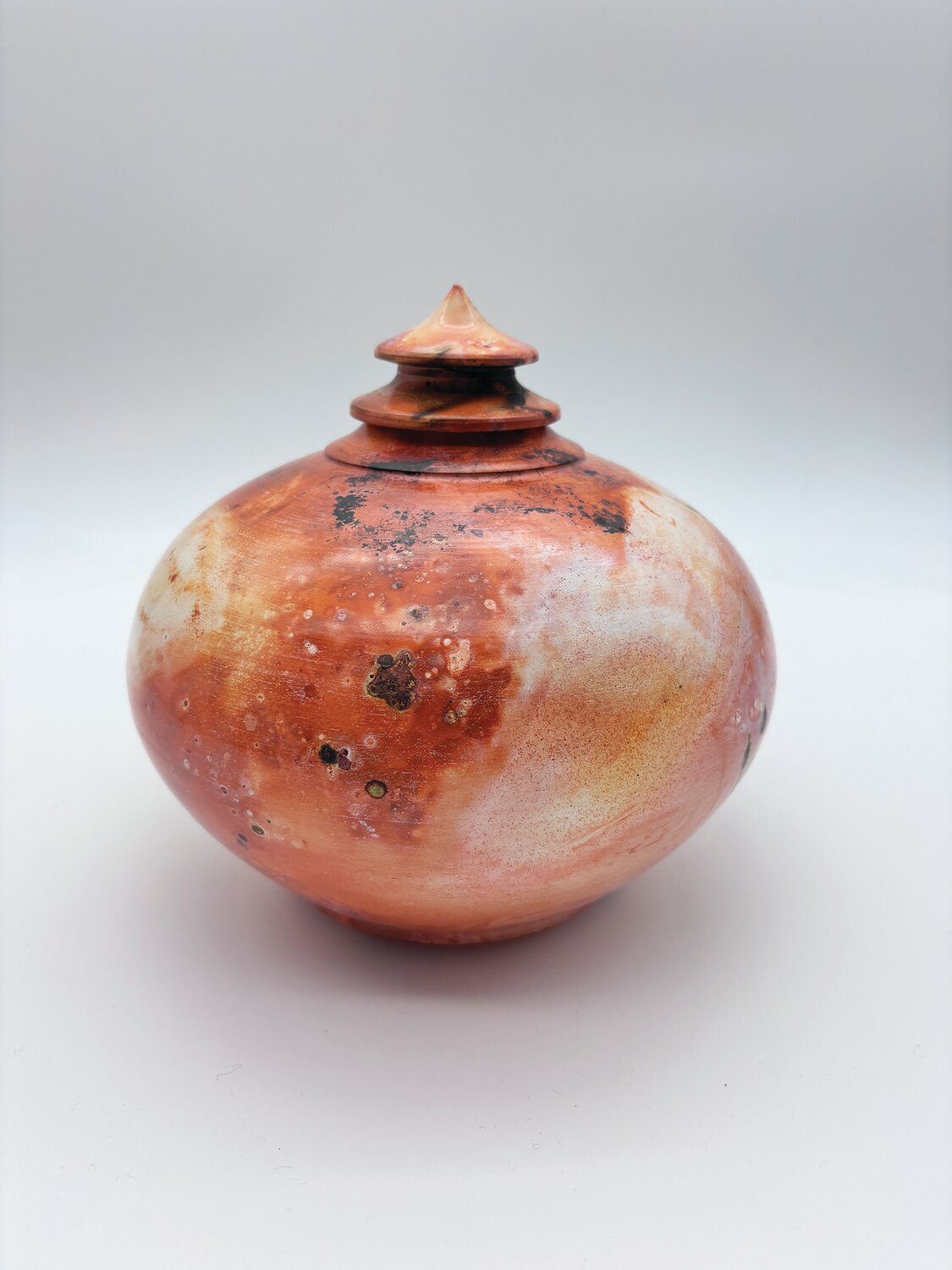 “Aluminum Foil Saggar Vessel, Orange,” a piece in stoneware, was created by Chris Sarley, instructor of adult pottery classes.