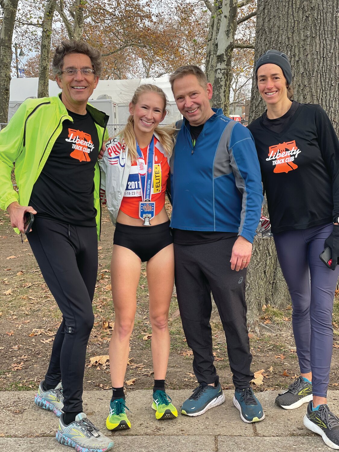 At the 2023 Philadelphia Half-Marathon, Veronica Eder, second from left, celebrates her strong finish with her dad, Jim, third from left, and family friends Matt Costello, left, and Tracey Sawyer, right.