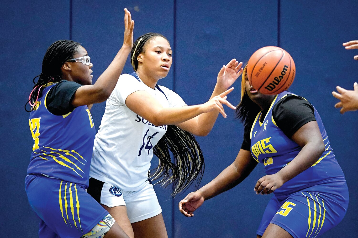 Solebury School’s Sarea Leonard-Jenkins splits the defense to get off a pass in front of The City School’s Janiah Green and Maiya Porter.