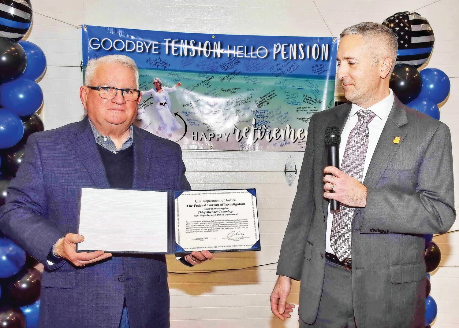 Standing in front of a sign that reads “Goodbye tension, hello pension,” New Hope Police Chief Michael Cummings accepts a commendation from the FBI at a retirement dinner Jan. 27  at the New Hope Eagle Fire Co.