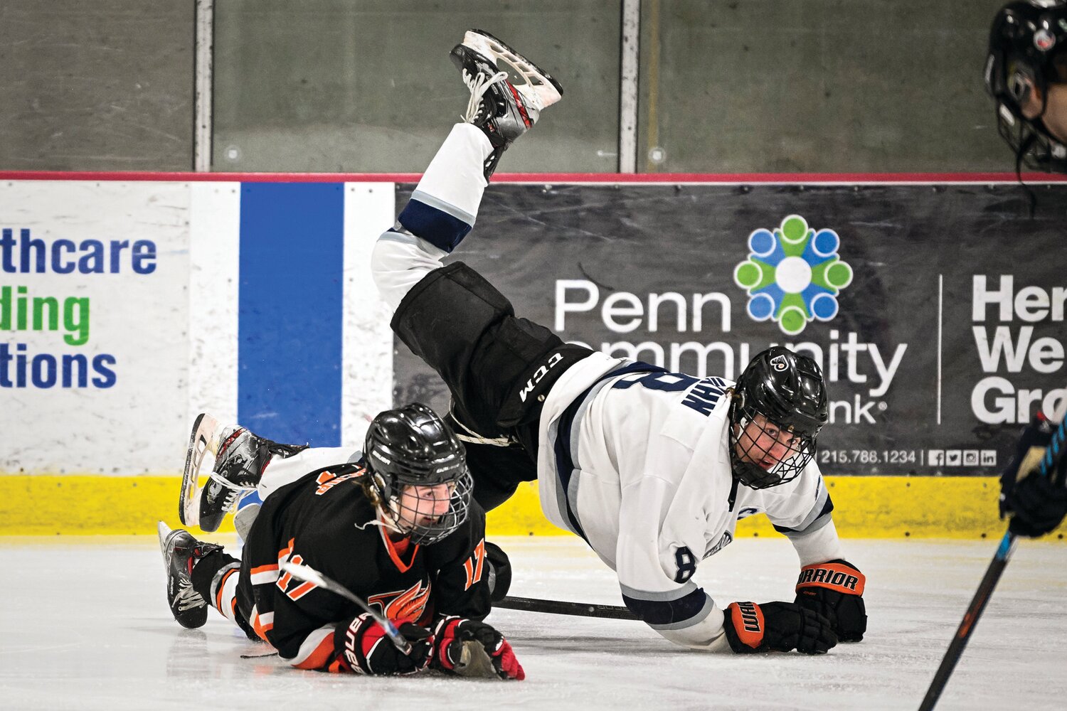 Council Rock North’s Nicholas Hahn gets upended from a check by Pennsbury’s Stevie Grosscup while going after a loose puck.