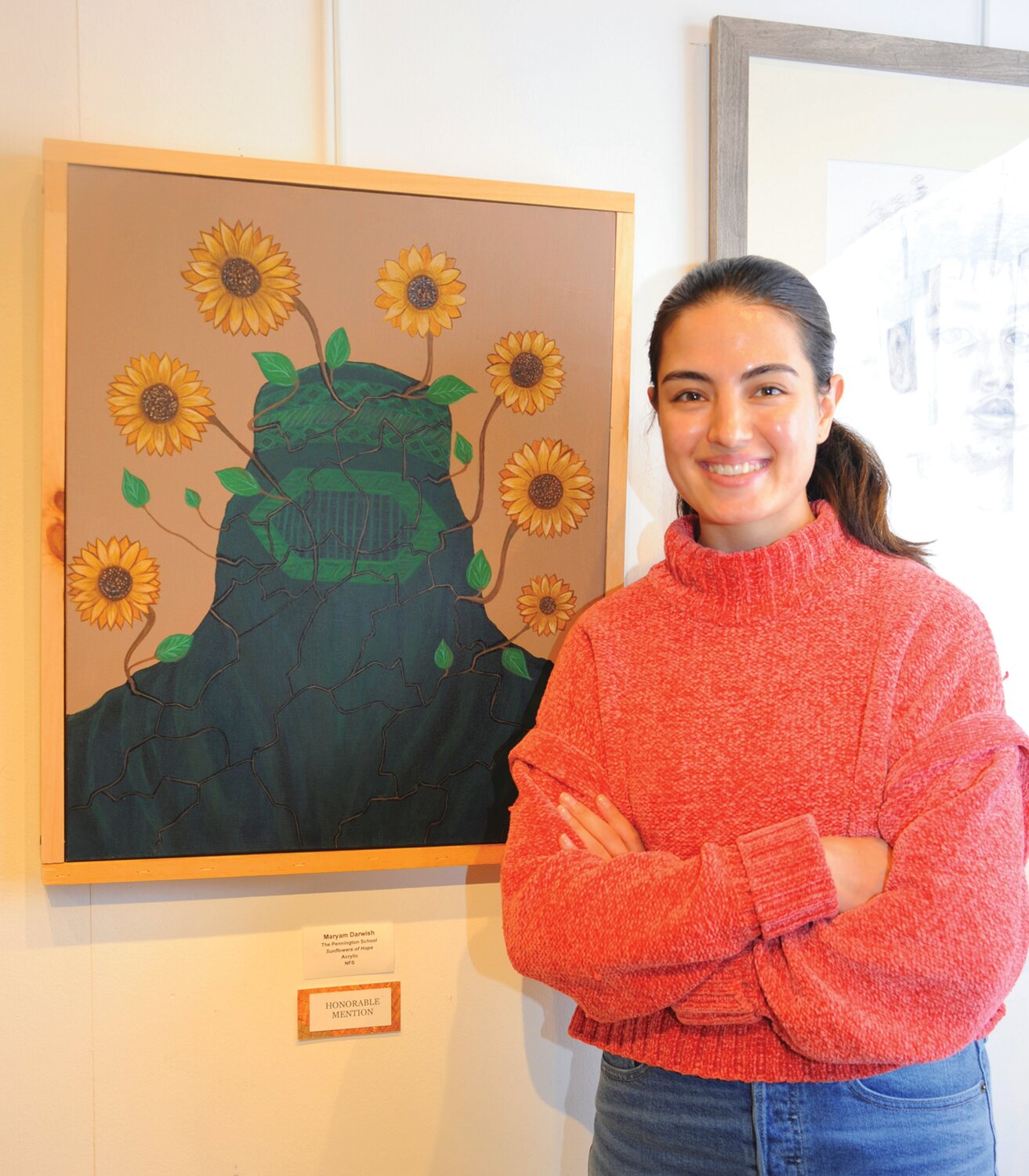 Hanifa stands with sister Maryam Darwish’s honorable mention painting “Sunflowers of Hope.”