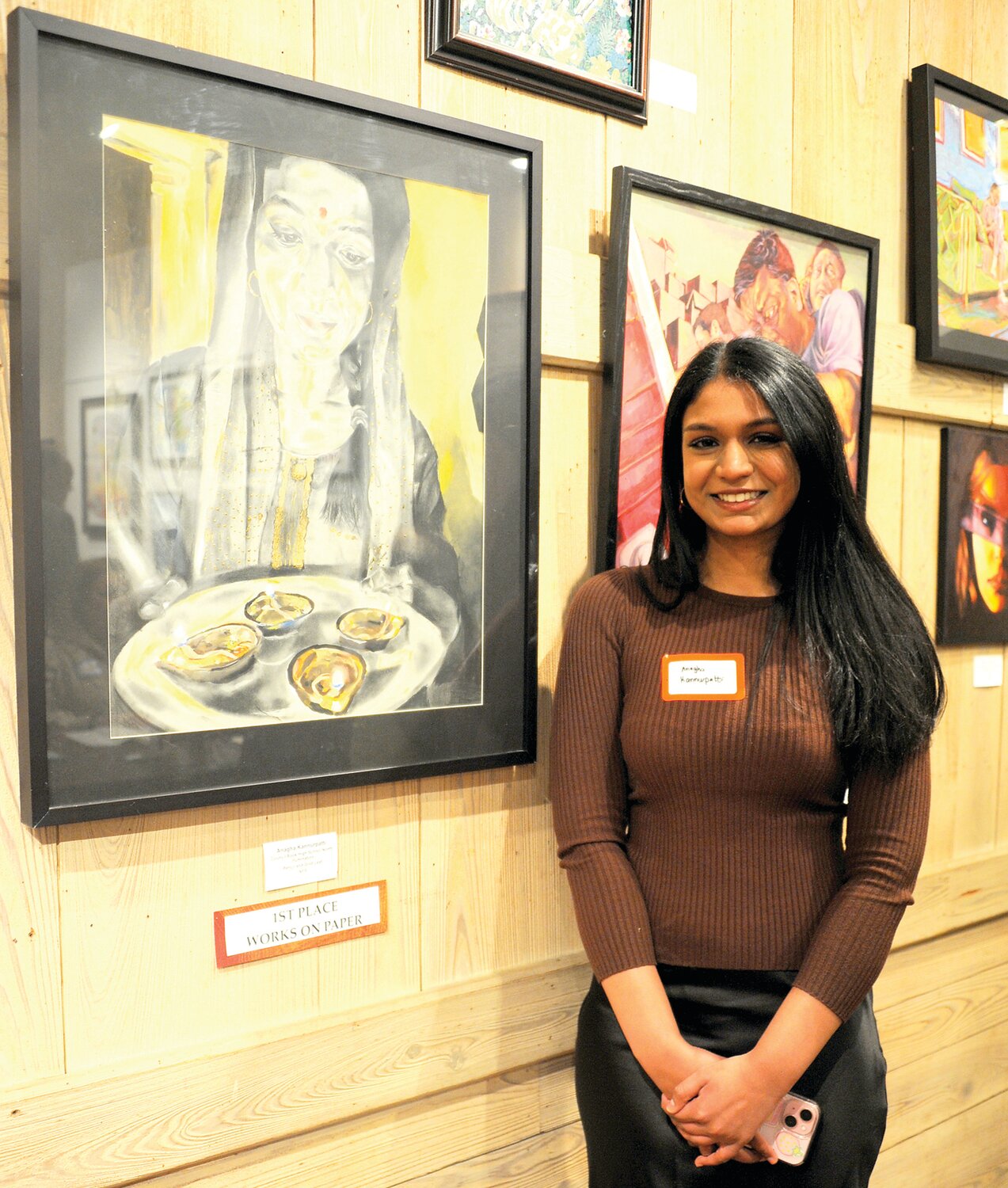 Anagha Kannurpatti stands next to her first-place work on paper “Illumination.”