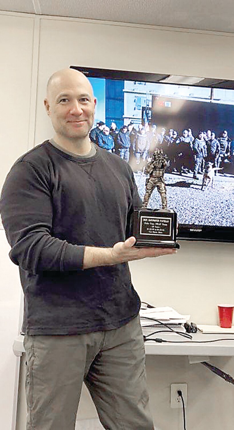 Sgt. Raymond Fanelli, a 27-year veteran of the Falls Township Police Department, holds his recognition award for 25 years of service to the South SWAT team.