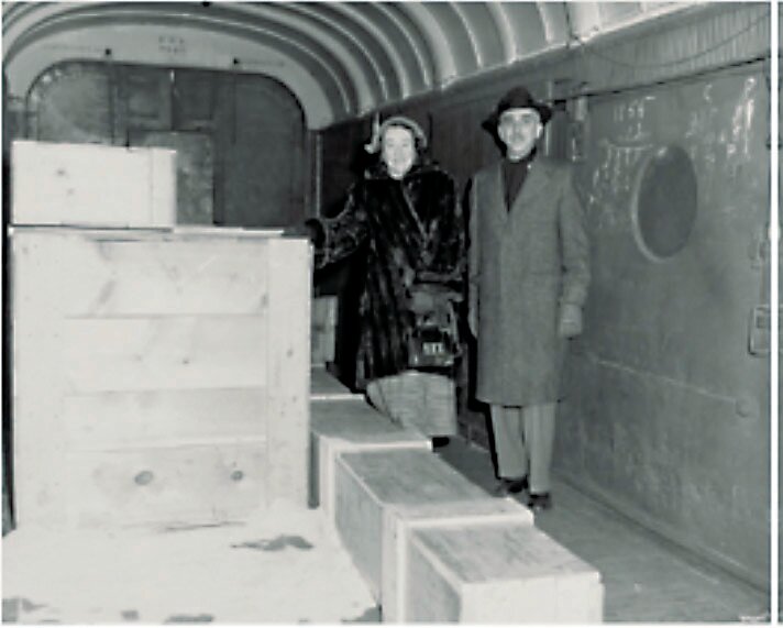 At the Trenton station in 1952, Ann Hawkes Hutton and Metropolitan Museum Conservator Murray Pease boarded the train that brought the painting “Washington Crossing the Delaware” to Bucks County. The painting is rolled up in a box at their feet.