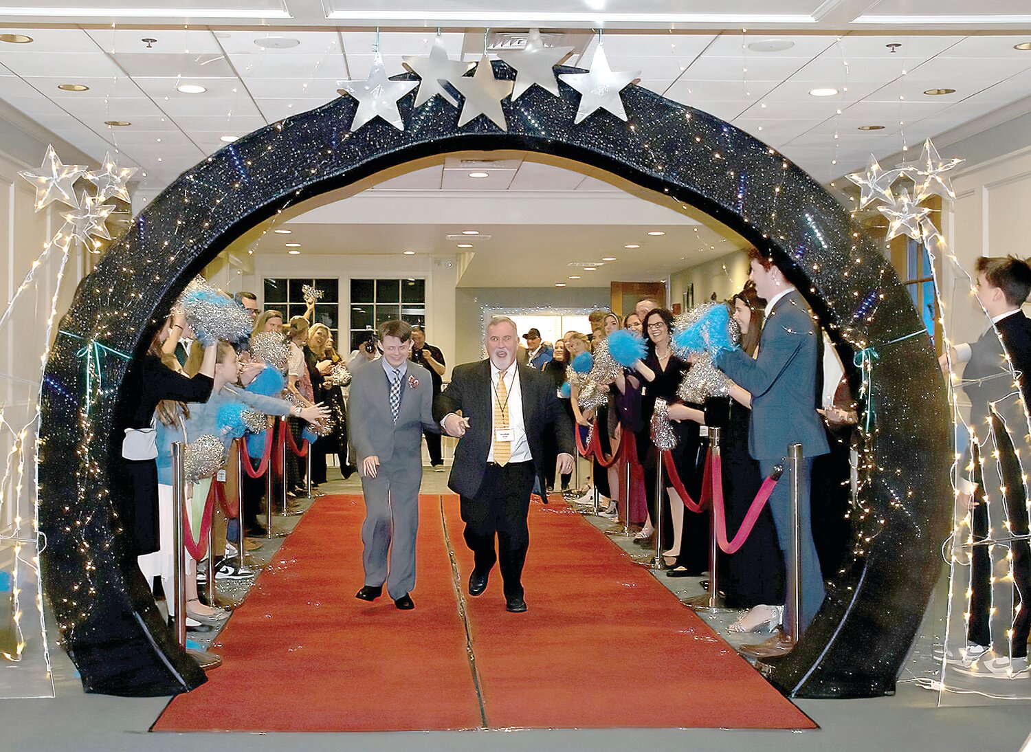Night to Shine attendees are celebrated as they walk in on the red carpet with their buddy.