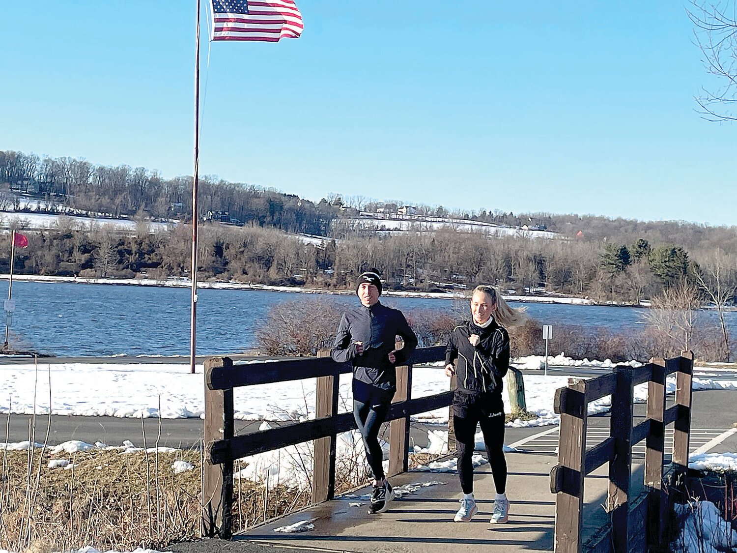 United States Olympic Marathon Trials runners Josh Izewski, left, and Veronica Eder run along the shoreline of Lake Galena, not far from where they grew up.